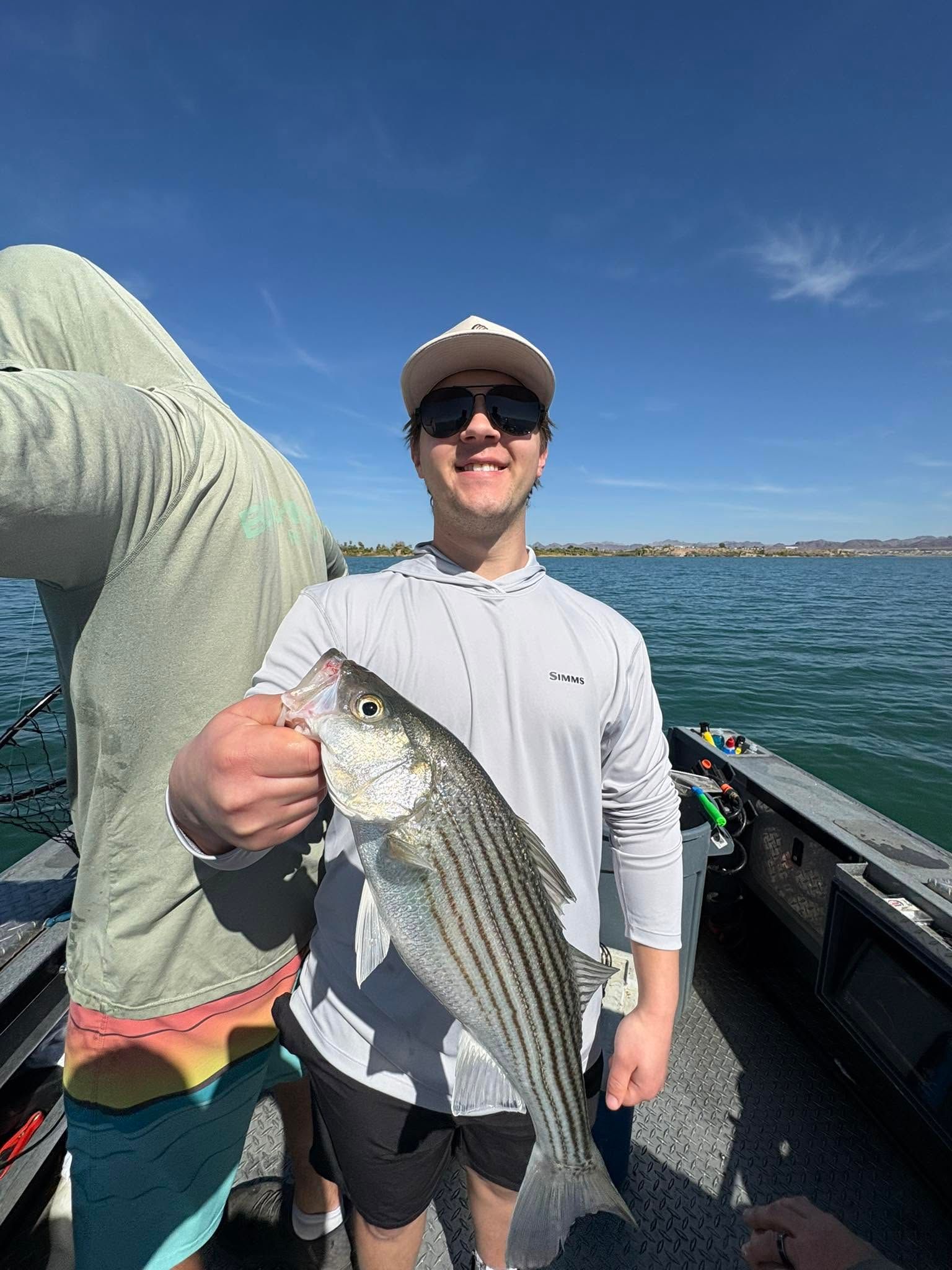 Freshly caught striped bass being held on fishing boat with ocean water in background