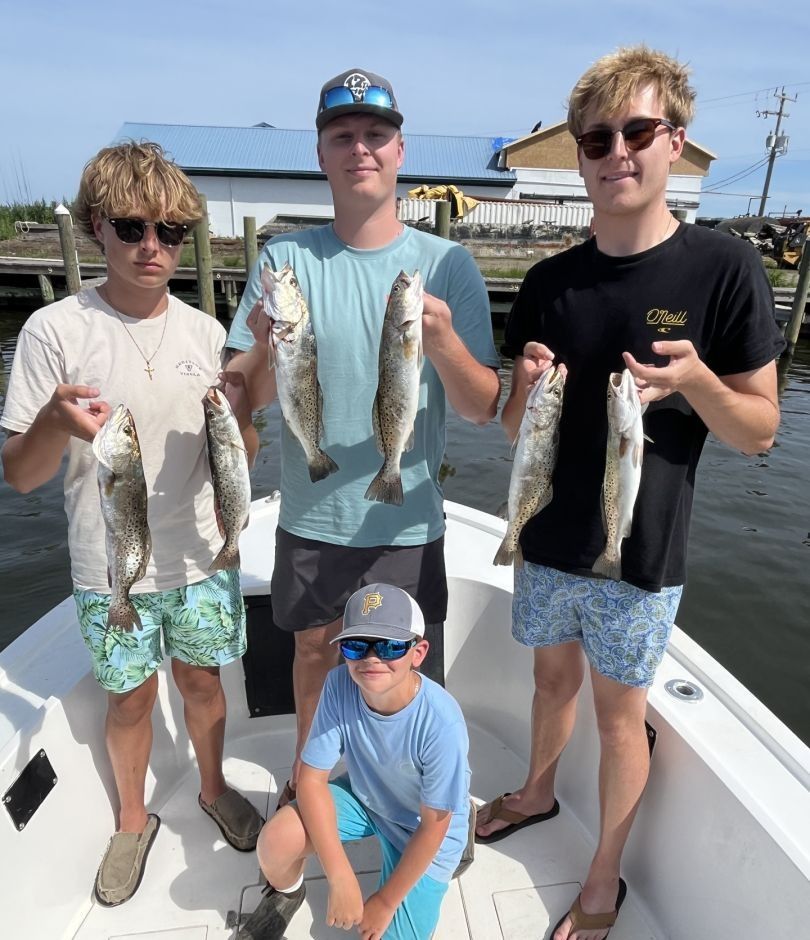 5 fishing rods with 4 people enjoying an unknown location