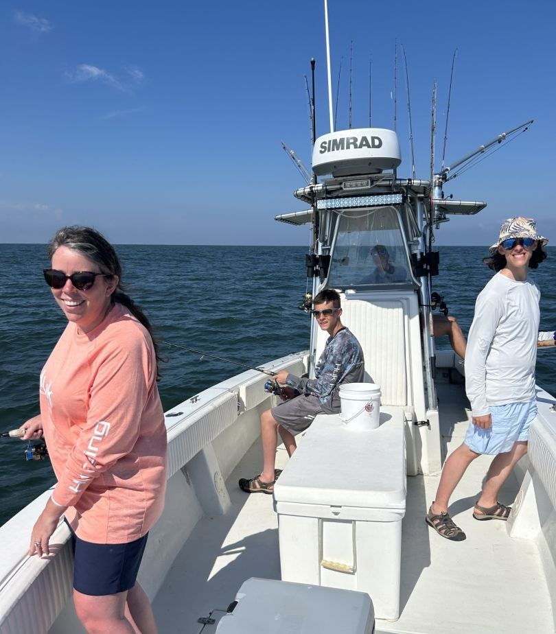 Three people fishing on a body of water