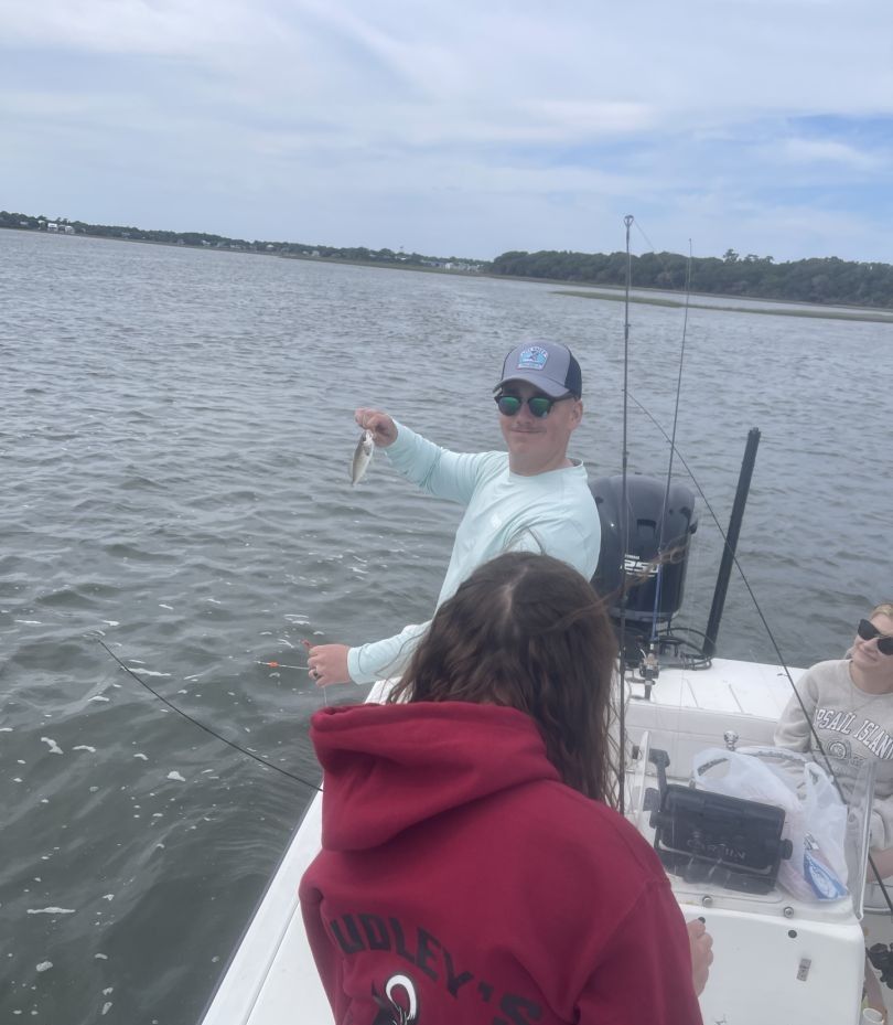 Fishing trip on calm waters with catch being displayed from boat