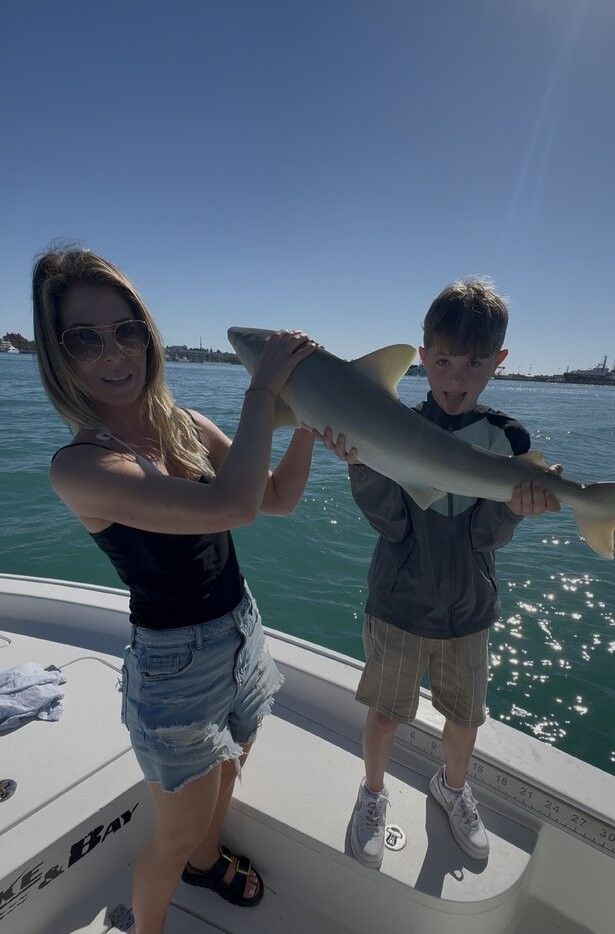 Freshly caught fish being displayed on fishing boat deck over clear blue water