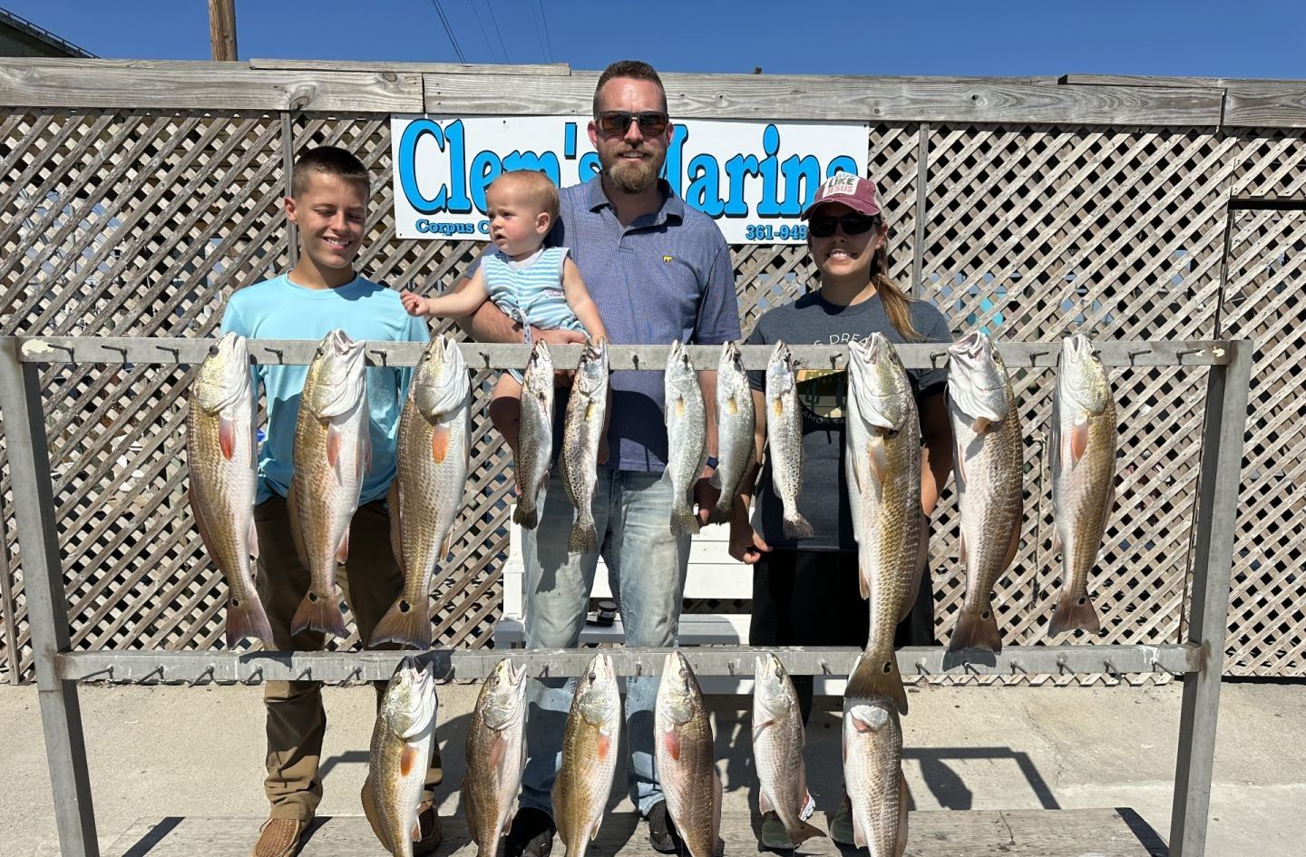 Fishermen catching 13 redfish in an unknown location
