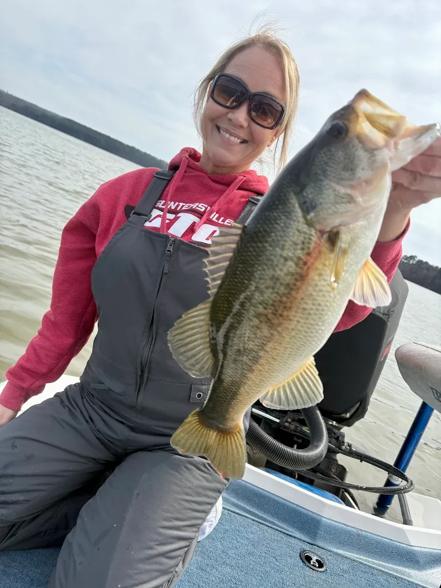 Bass fish being held up on fishing boat showing successful catch