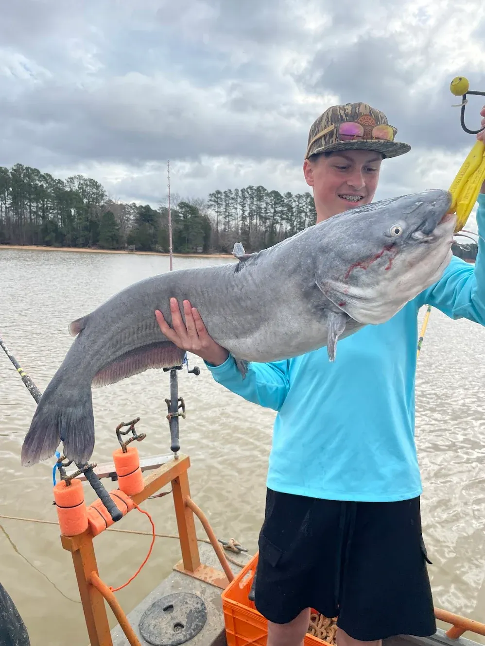 Blue catfish catch displayed on fishing boat with rod holders and tackle equipment