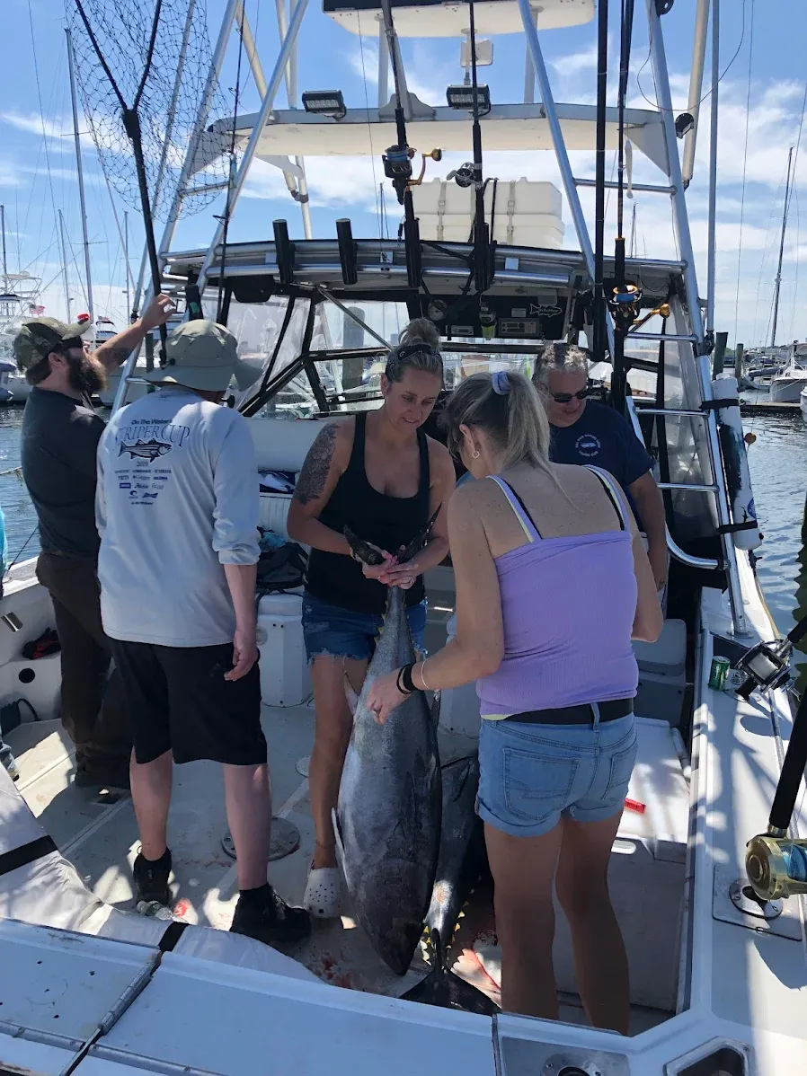 Fresh caught bluefin tuna displayed on fishing boat deck with charter fishing equipment visible