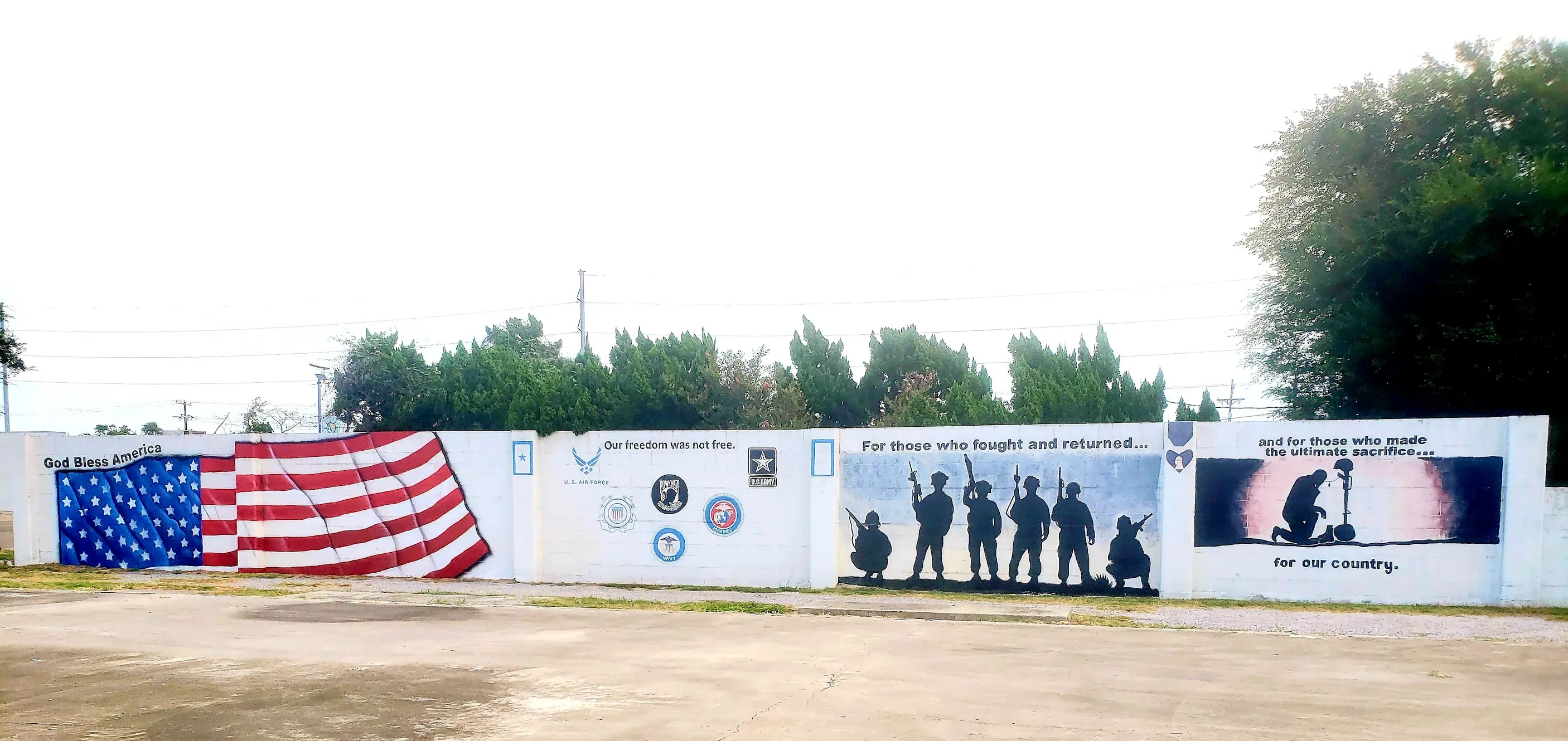 Patriotic mural featuring American flag and military service tribute on outdoor wall