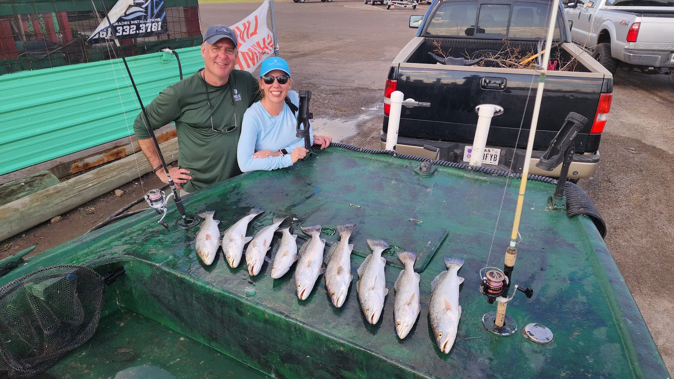 Successful speckled trout fishing trip with multiple fish displayed on cleaning table with fishing gear