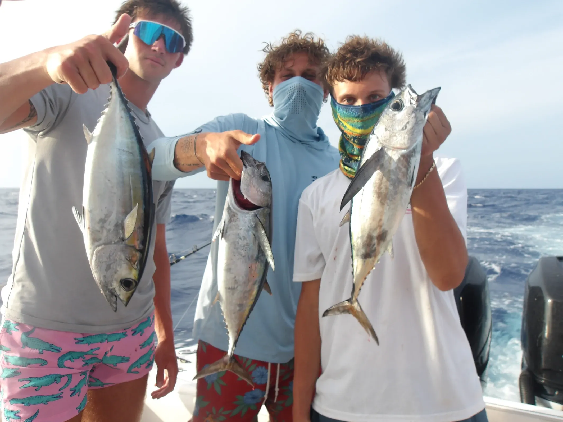 Three fresh caught tuna fish displayed on fishing boat deck over ocean waters