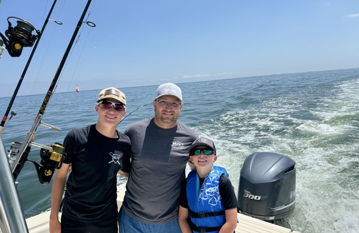 Three people fishing at an unknown location.