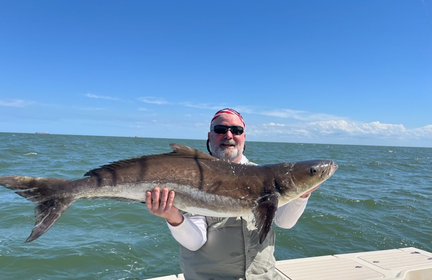 A person fishing with a large fish caught on the line