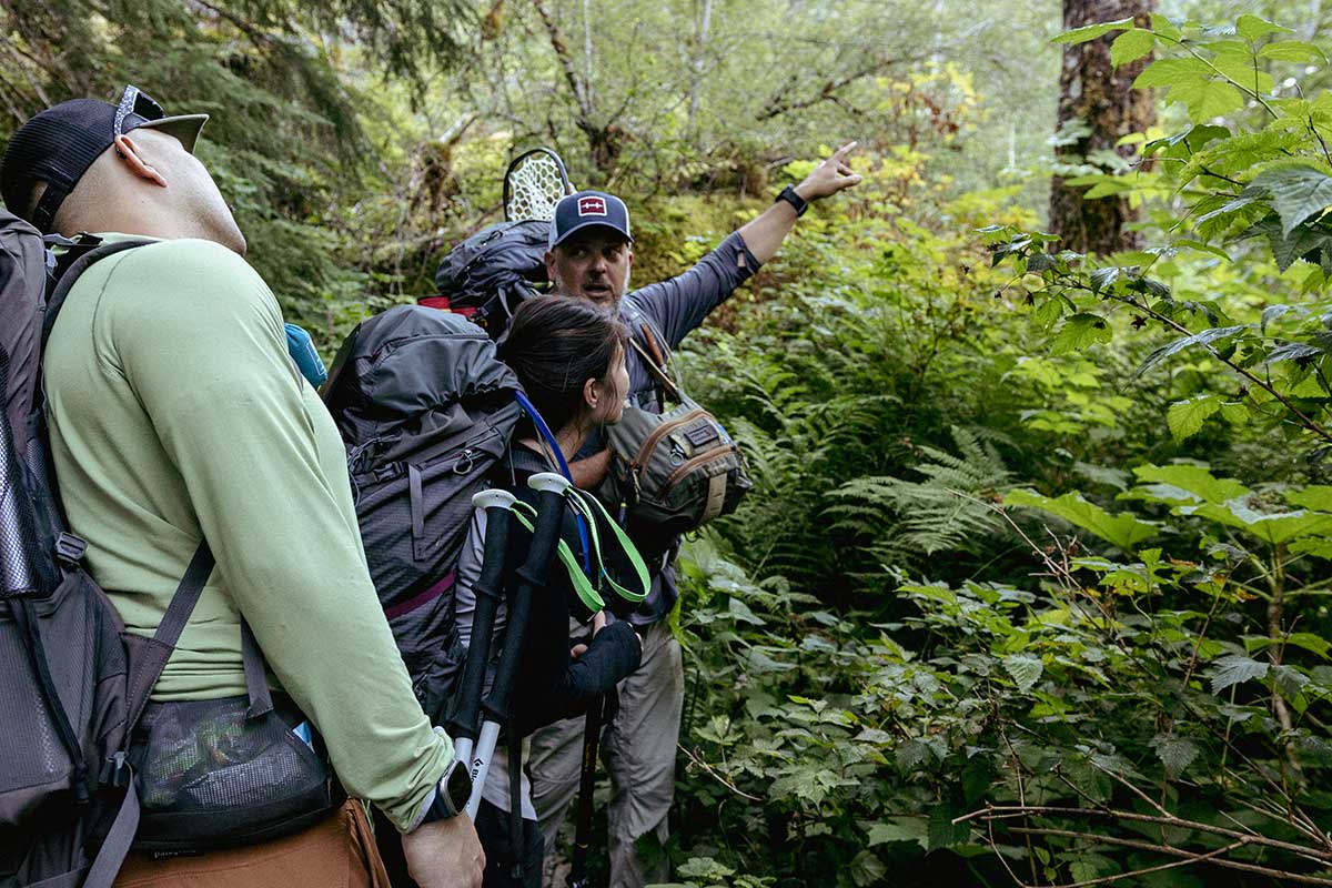 Guide pointing and leading group through lush forest terrain in Gig Harbor Washington