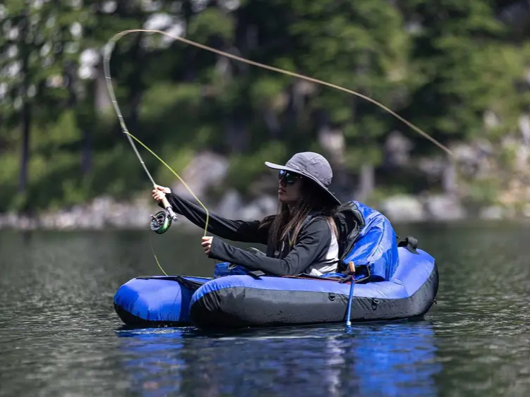 Private fly fishing guide with angler in float tube on alpine lake in Washington wilderness