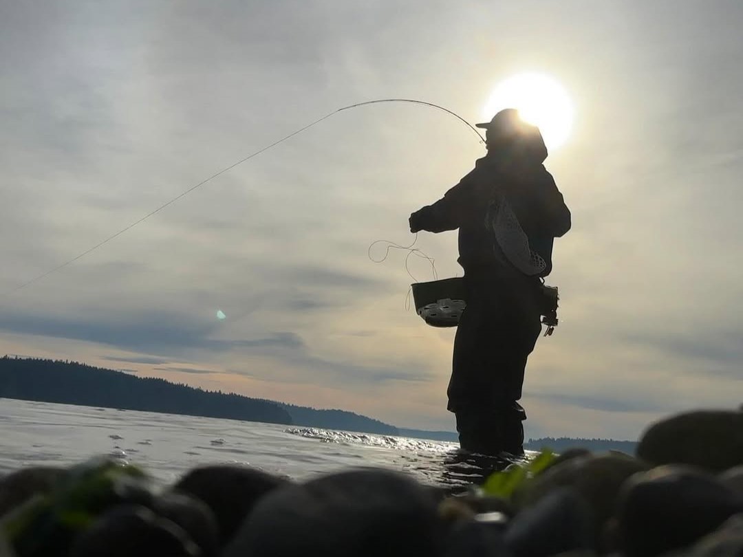 Captain Kyle guiding fly fishing for Coastal Cutthroat Trout on Puget Sound beach