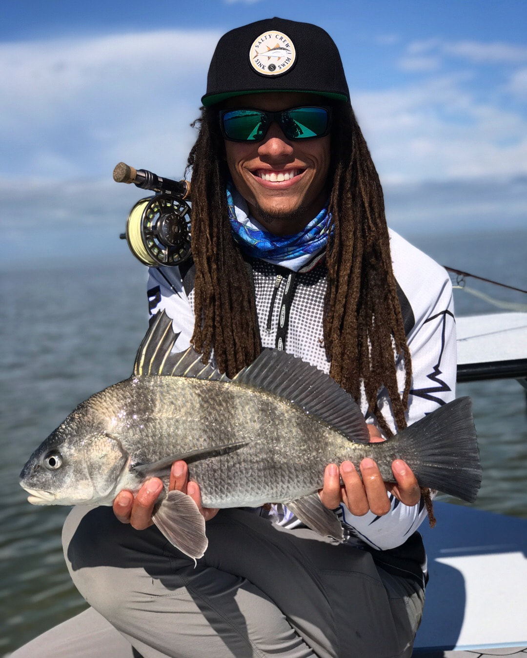 A person holding a caught black drum fish in Orlando.