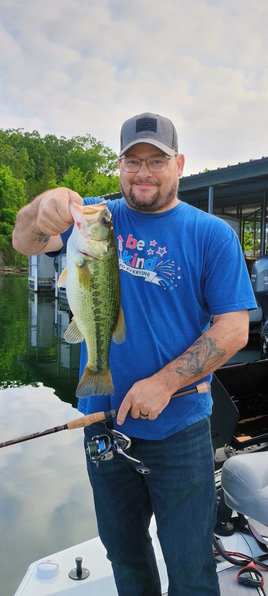 Angler holding caught bass while fishing in Branson Missouri