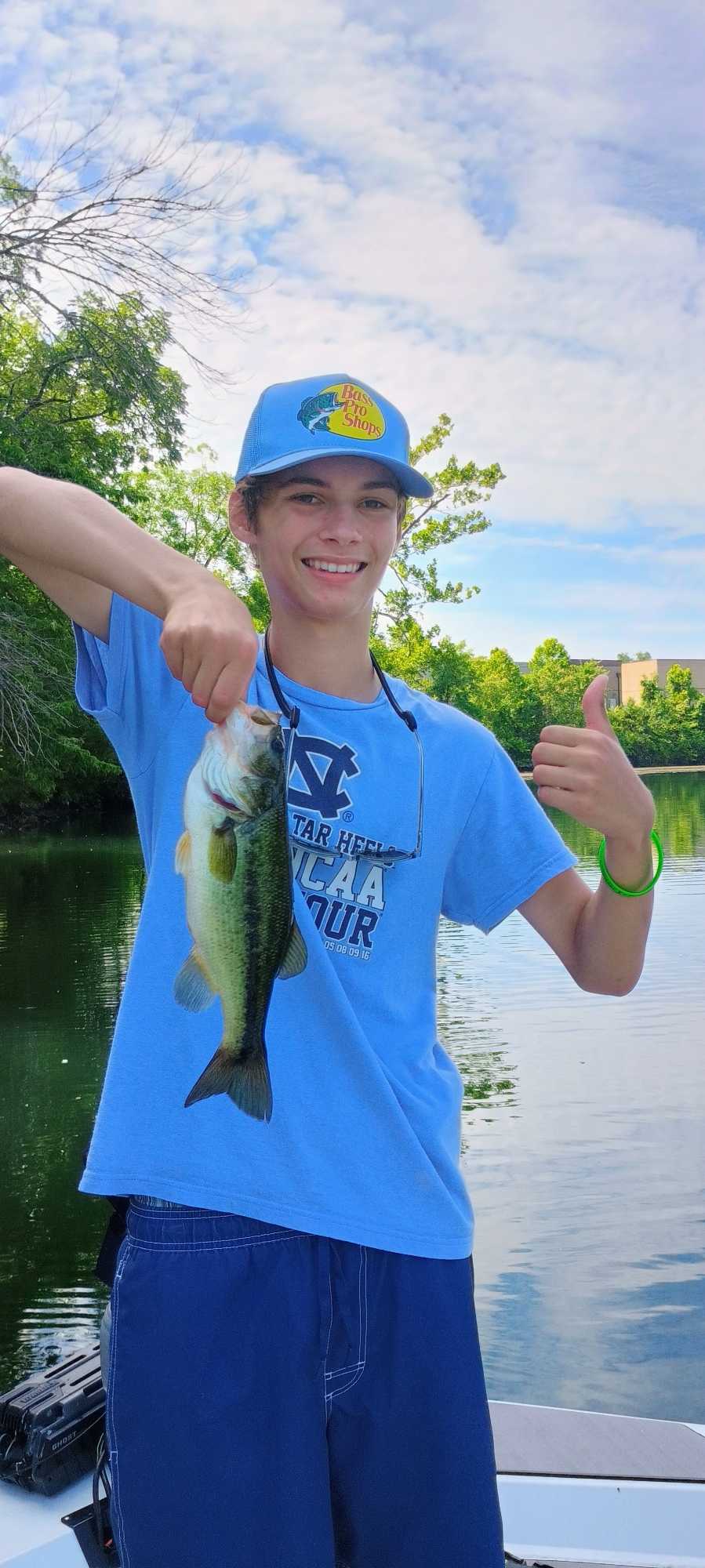 Angler holding freshly caught bass while fishing in Branson MO