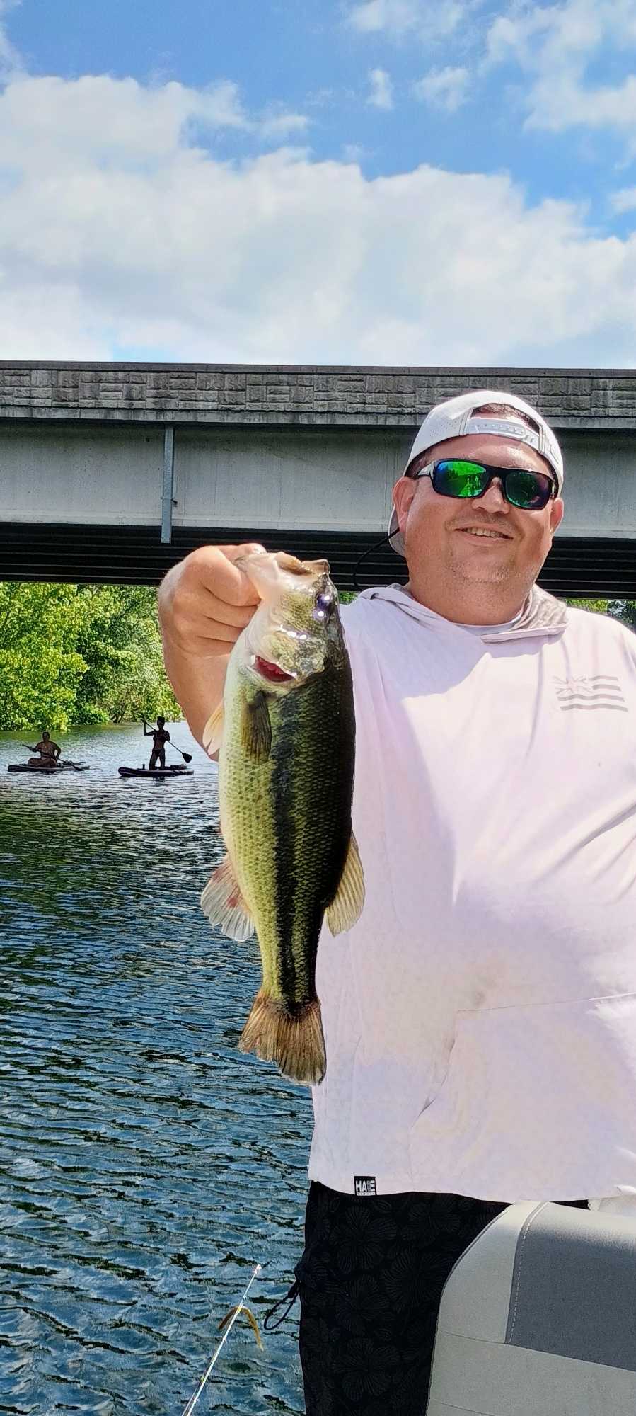 Angler holding freshly caught bass while fishing in Branson MO