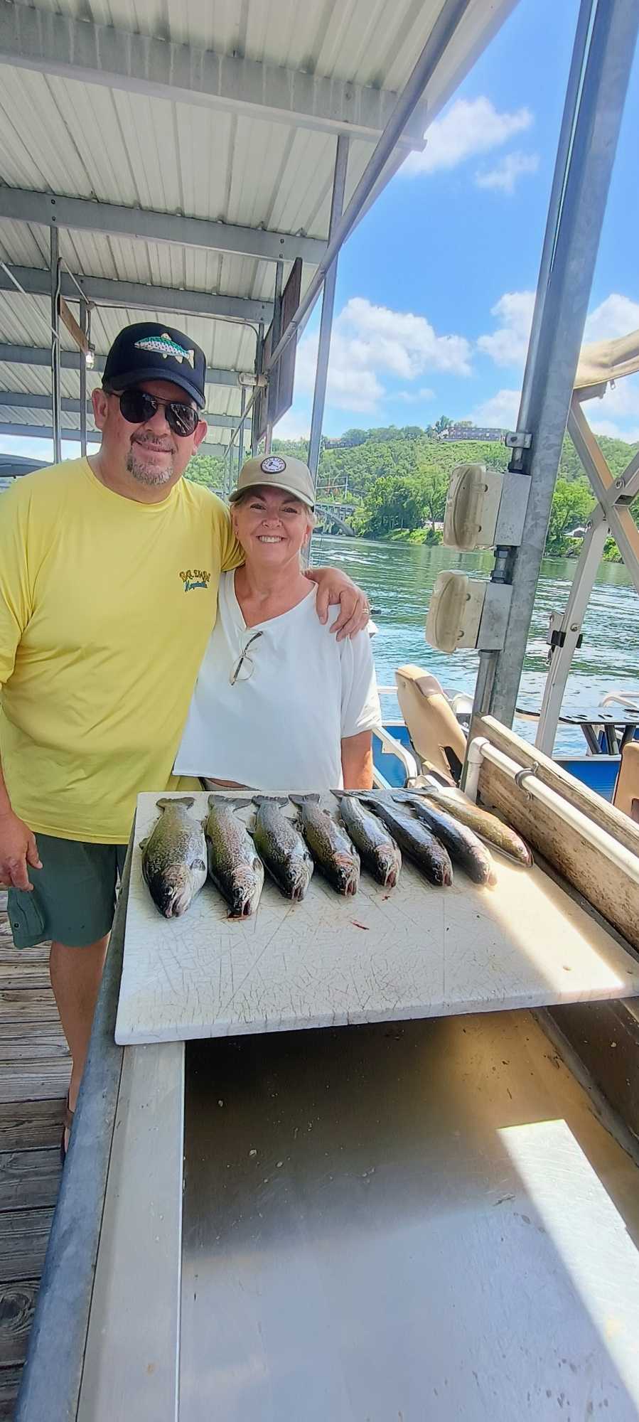 Fresh caught fish displayed on cleaning station at Branson MO fishing dock with lake and trees in background