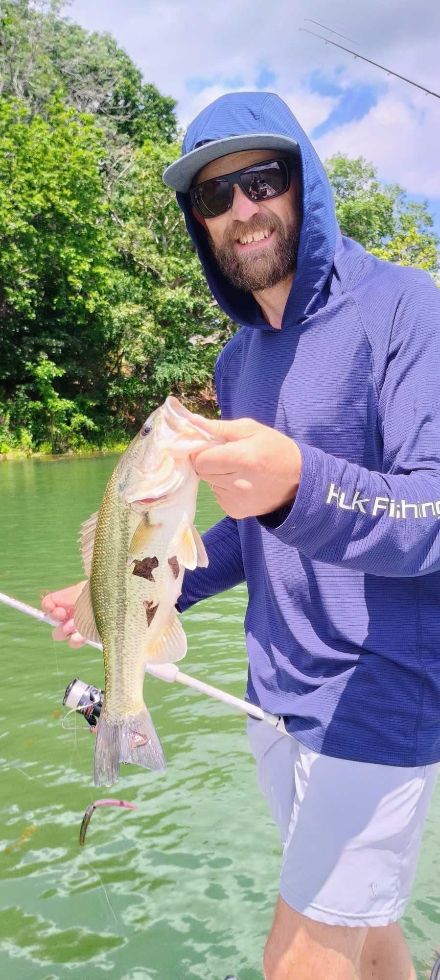 Angler holding freshly caught bass on boat in Branson MO