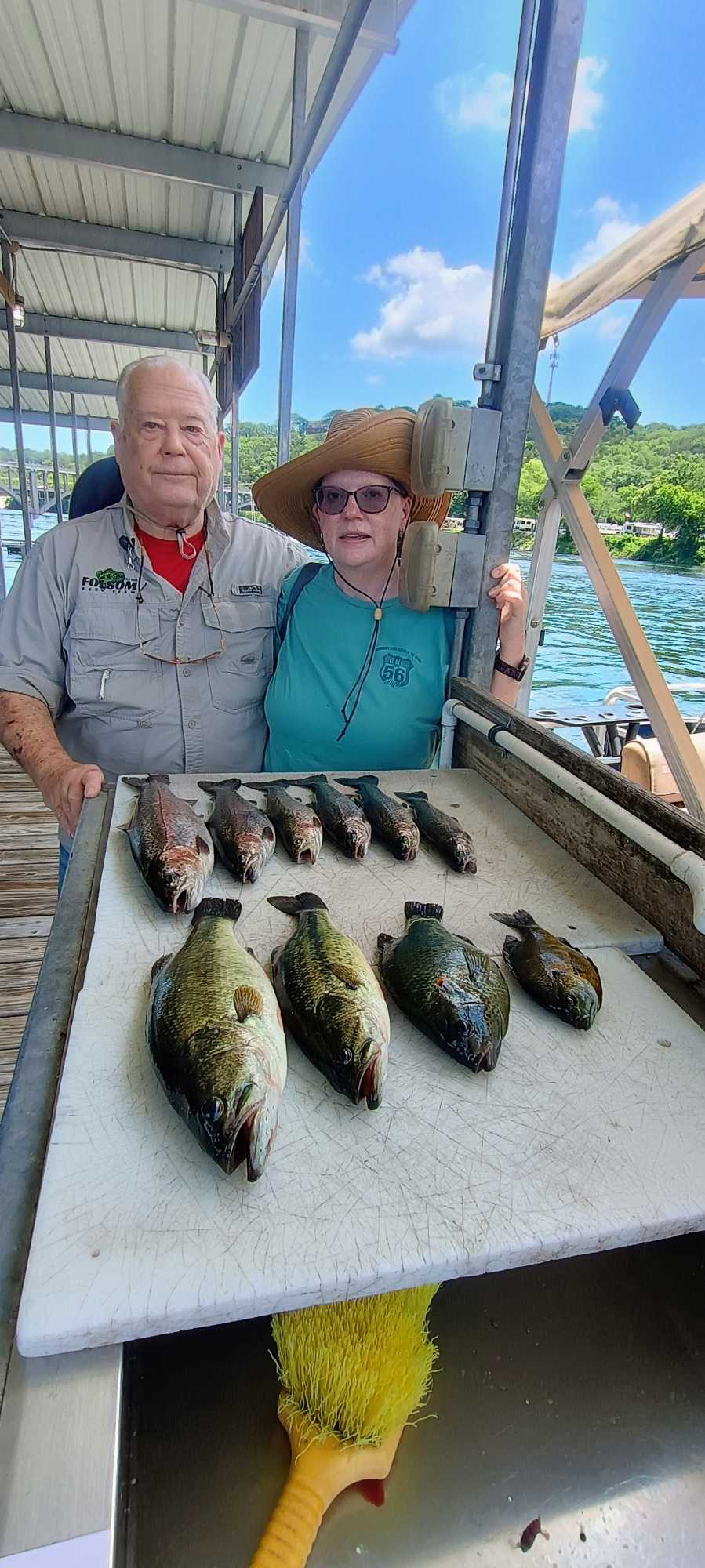 Fresh caught bass and other fish displayed on cleaning table at Branson MO fishing dock