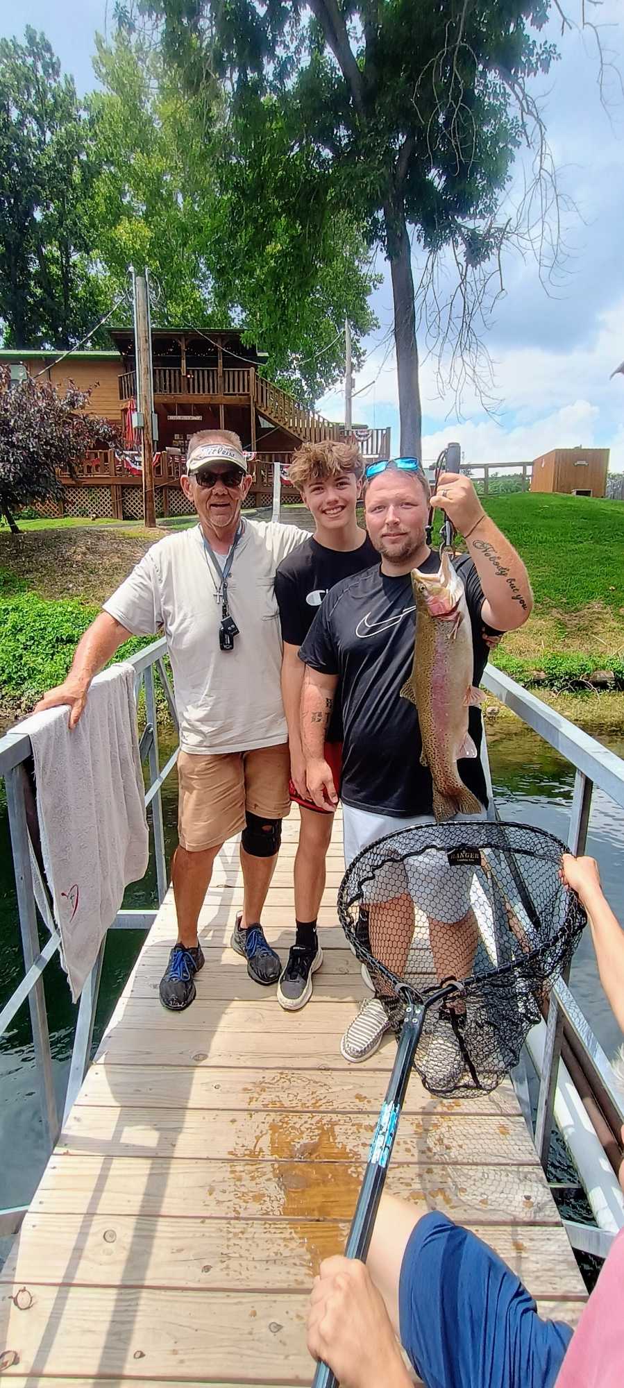 Rainbow trout fishing catch on wooden dock in Branson MO with fishing net