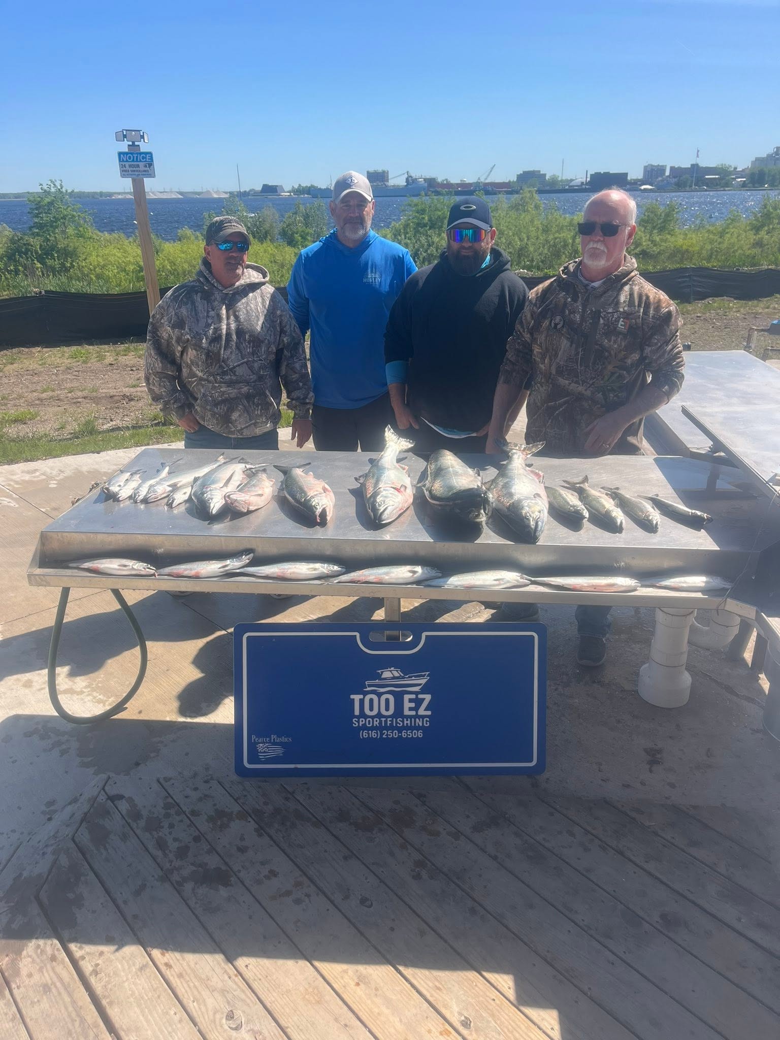 Successful fishing charter results displayed on cleaning table in Muskegon MI with large lake salmon and trout catch