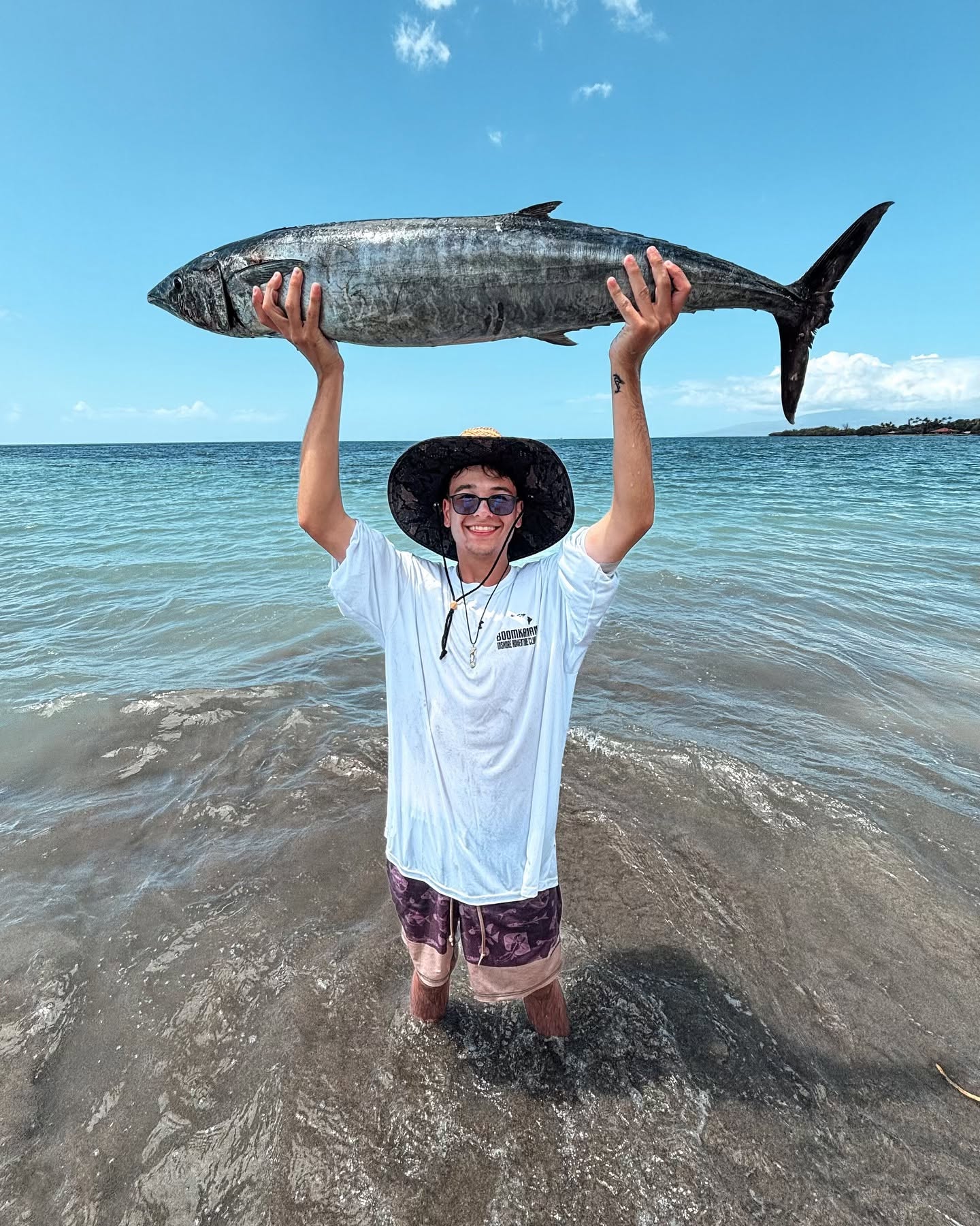 Wahoo fish catch held up on beach in Lahaina Hawaii