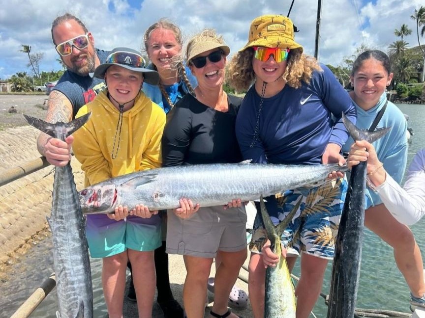 A group of 6 people fishing on the beach in HI