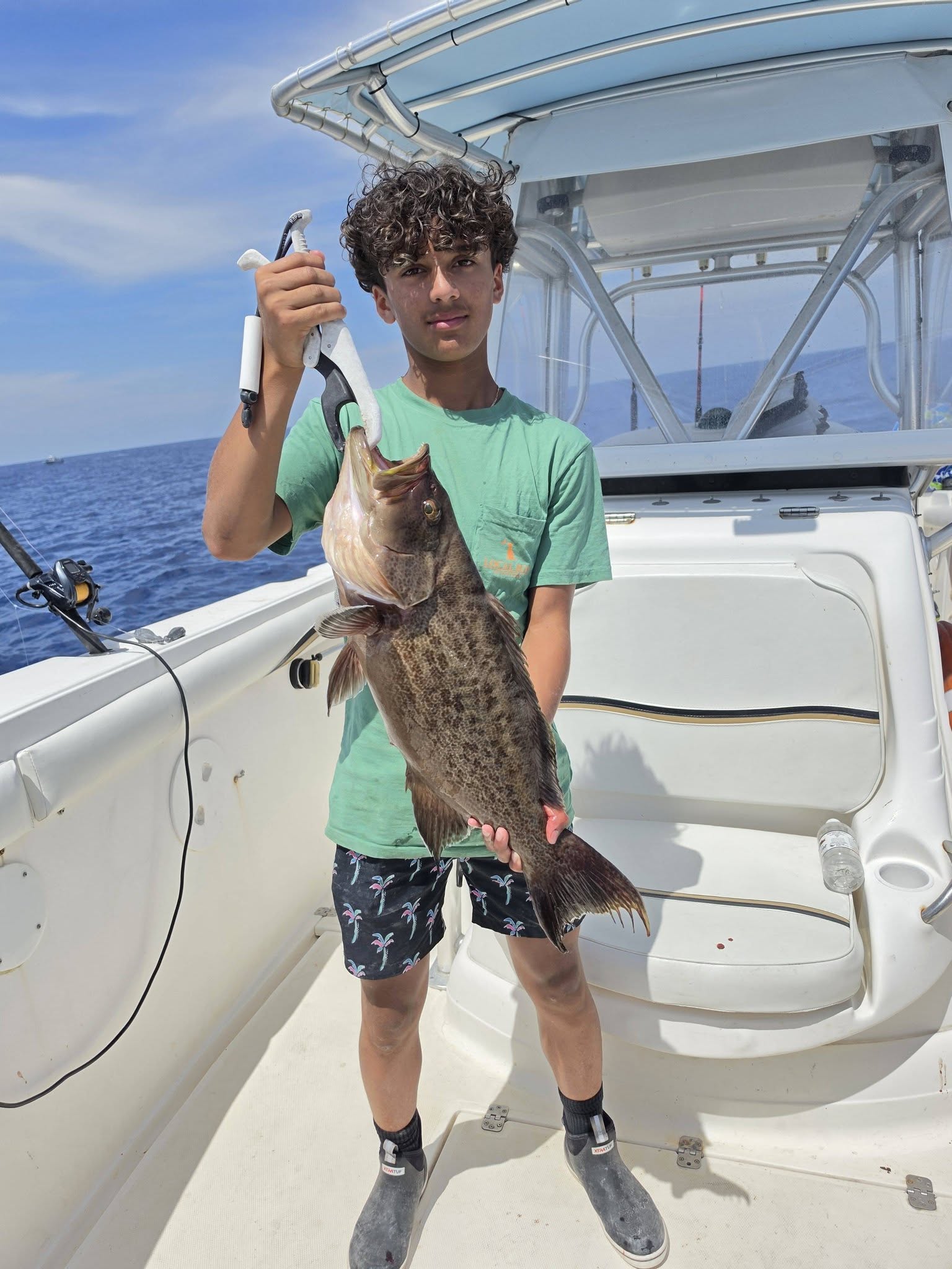 Angler holding freshly caught fish on fishing boat in Oak Island NC waters