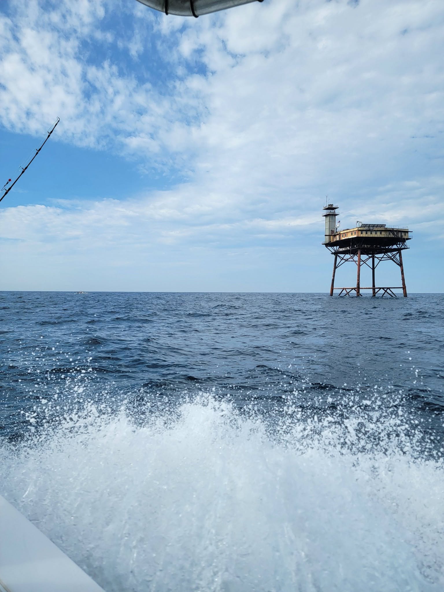 Fishing boat wake with offshore platform structure in Oak Island NC waters