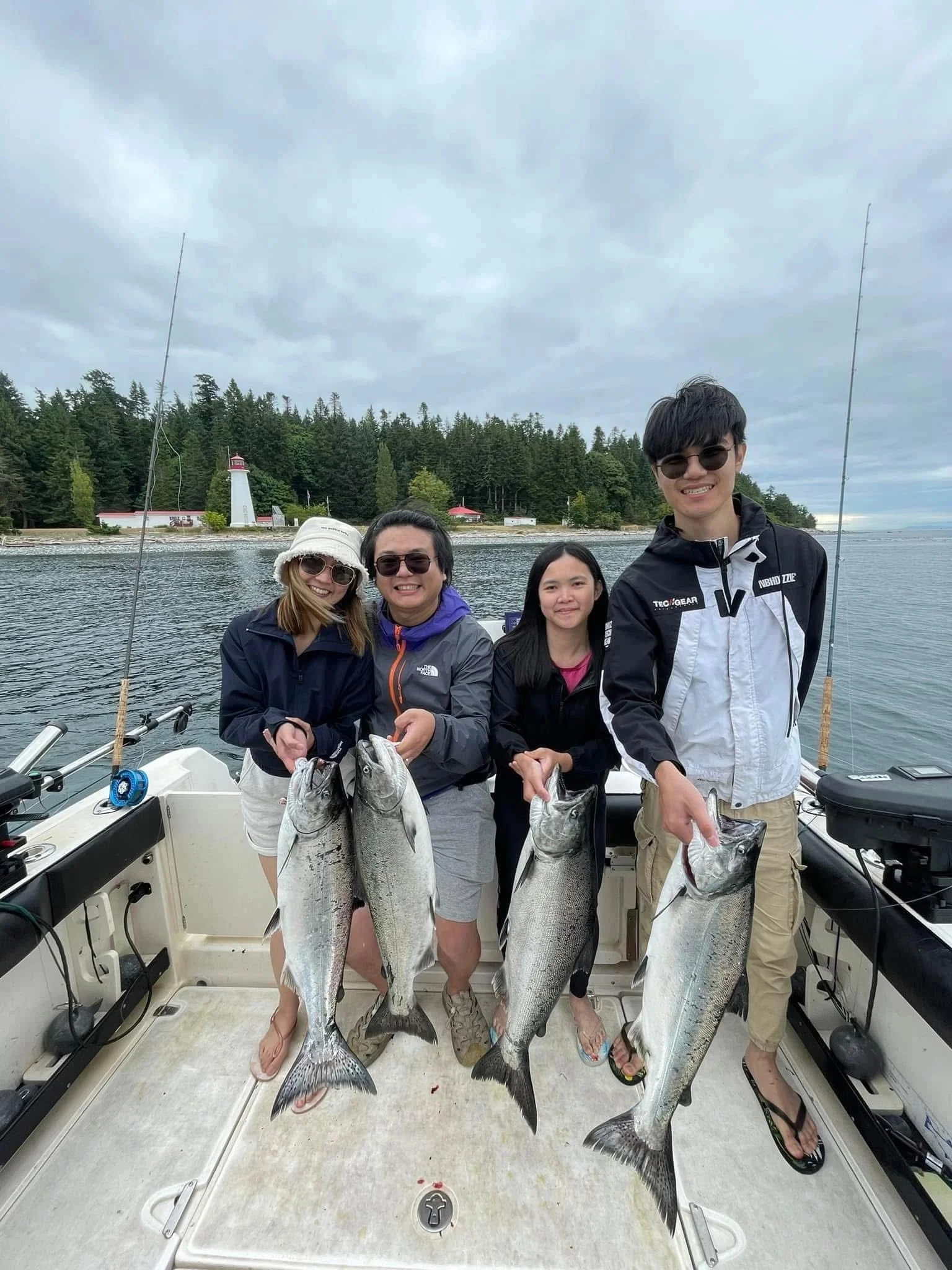 Four large Chinook salmon caught on fishing charter boat near Campbell River BC with lighthouse visible in background