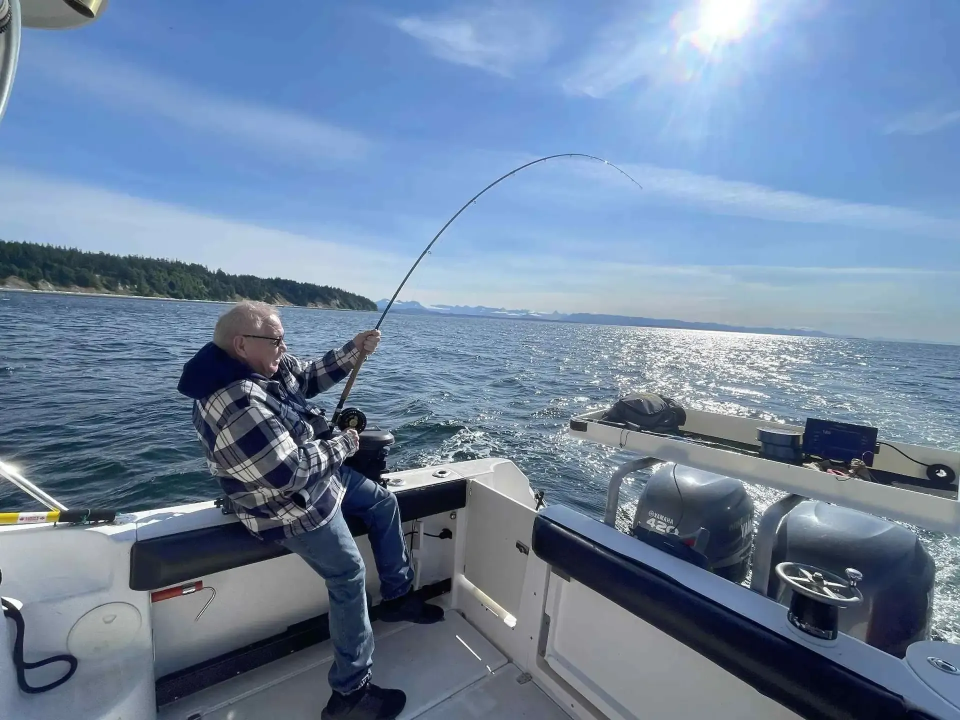 Fishing rod bent with catch on boat in Campbell River BC waters