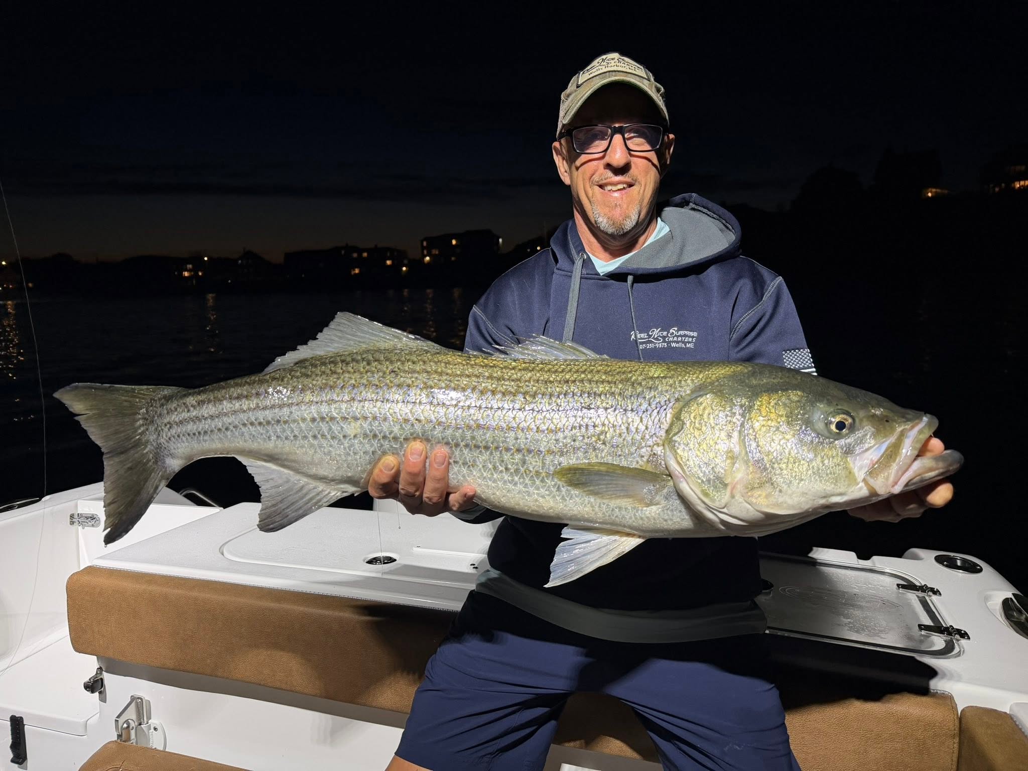 Striped bass caught while fishing in Wells ME displayed on boat at night