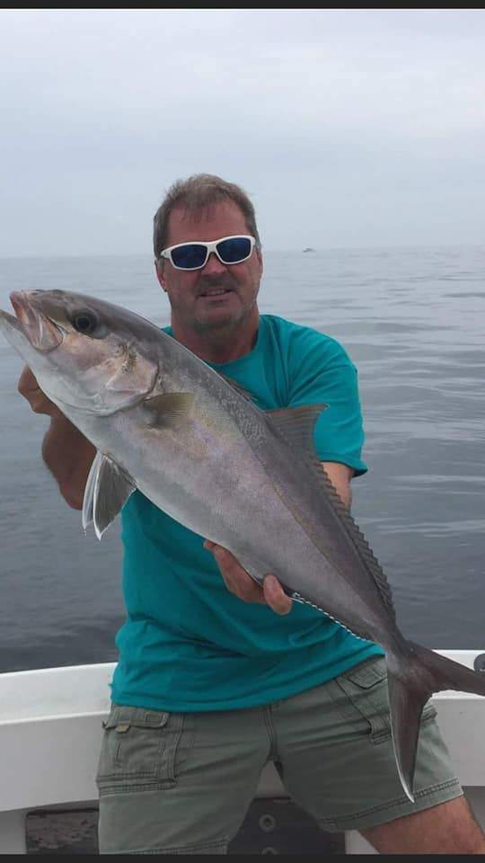 A fisherman holding a large, 22-inch fish in FL