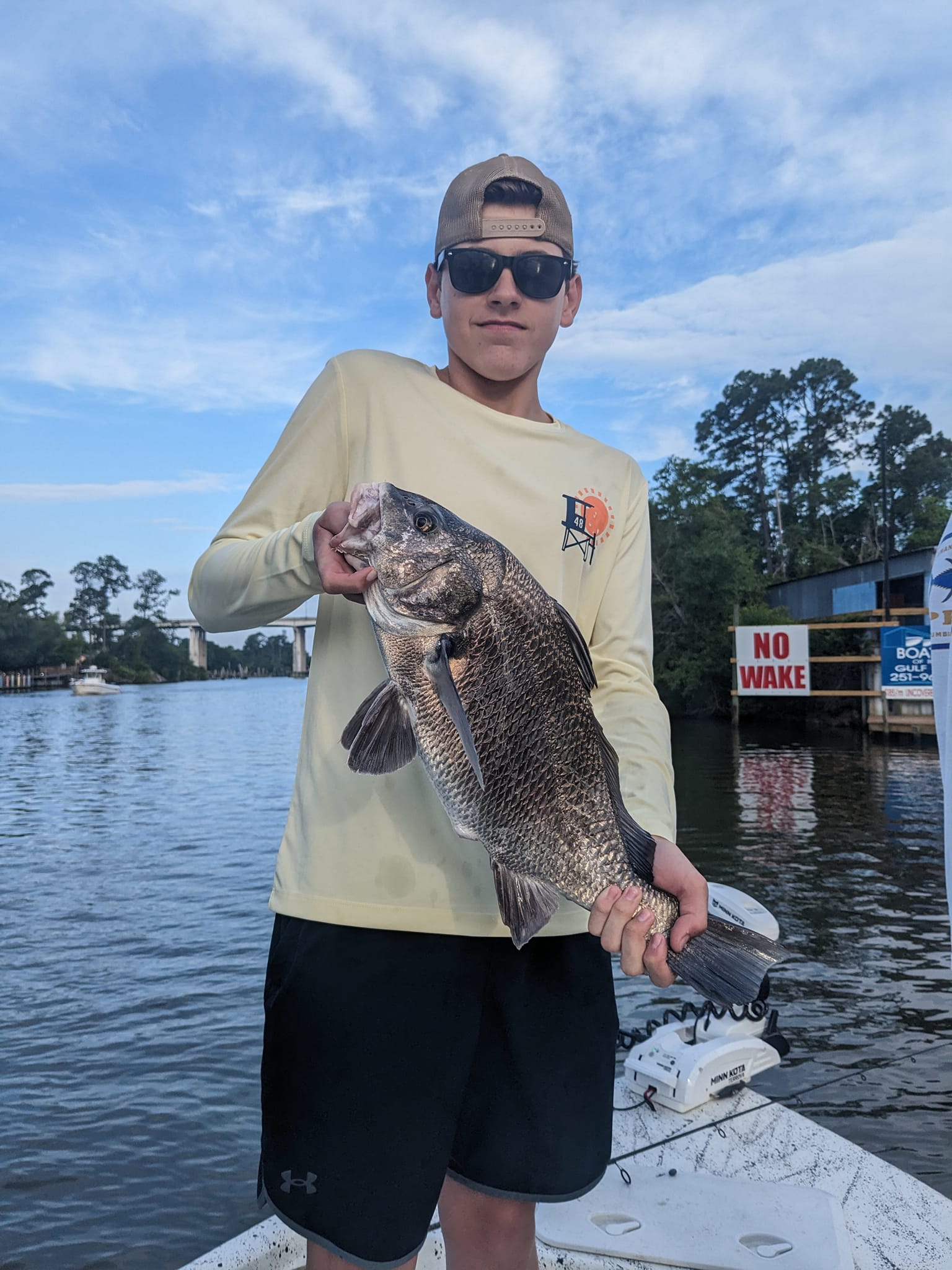 A fisherman catches a Black Drum fish in Gulf Shores