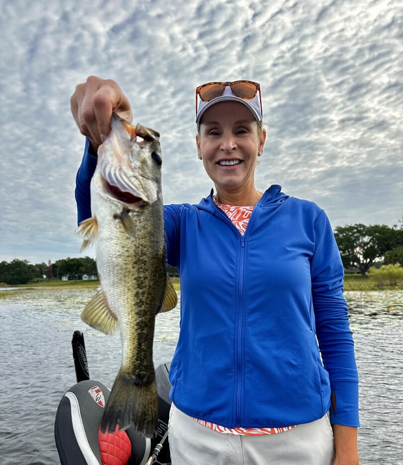 Angler holding freshly caught bass on fishing boat in Winter Garden FL