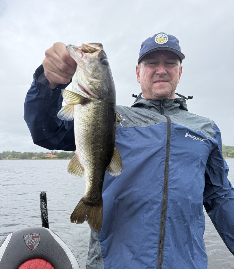 Angler holding freshly caught bass on fishing boat in Winter Garden Florida