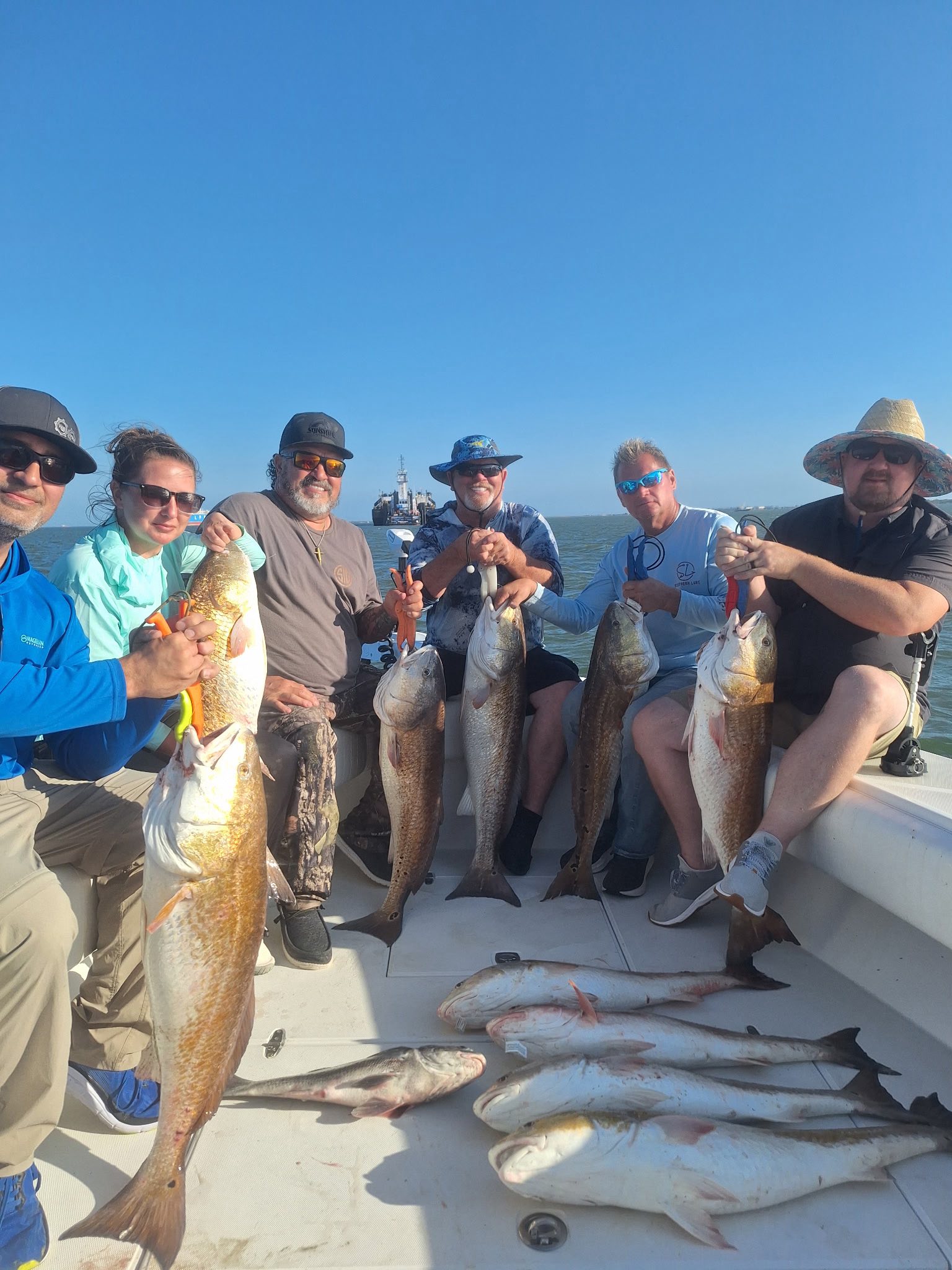 Successful fishing charter in Galveston TX displaying multiple redfish caught on boat deck