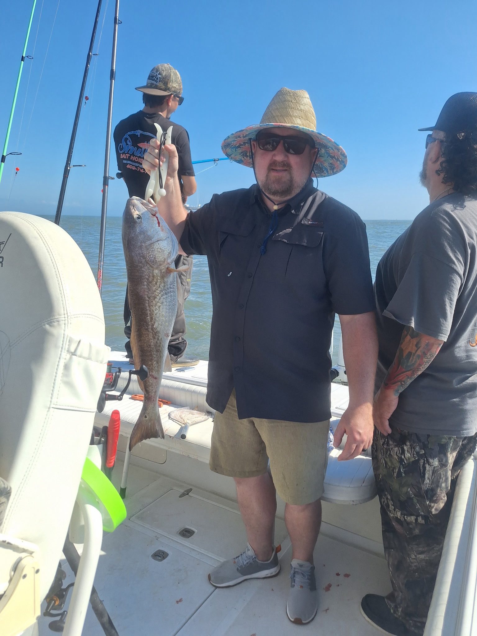 Angler holding caught redfish on fishing boat