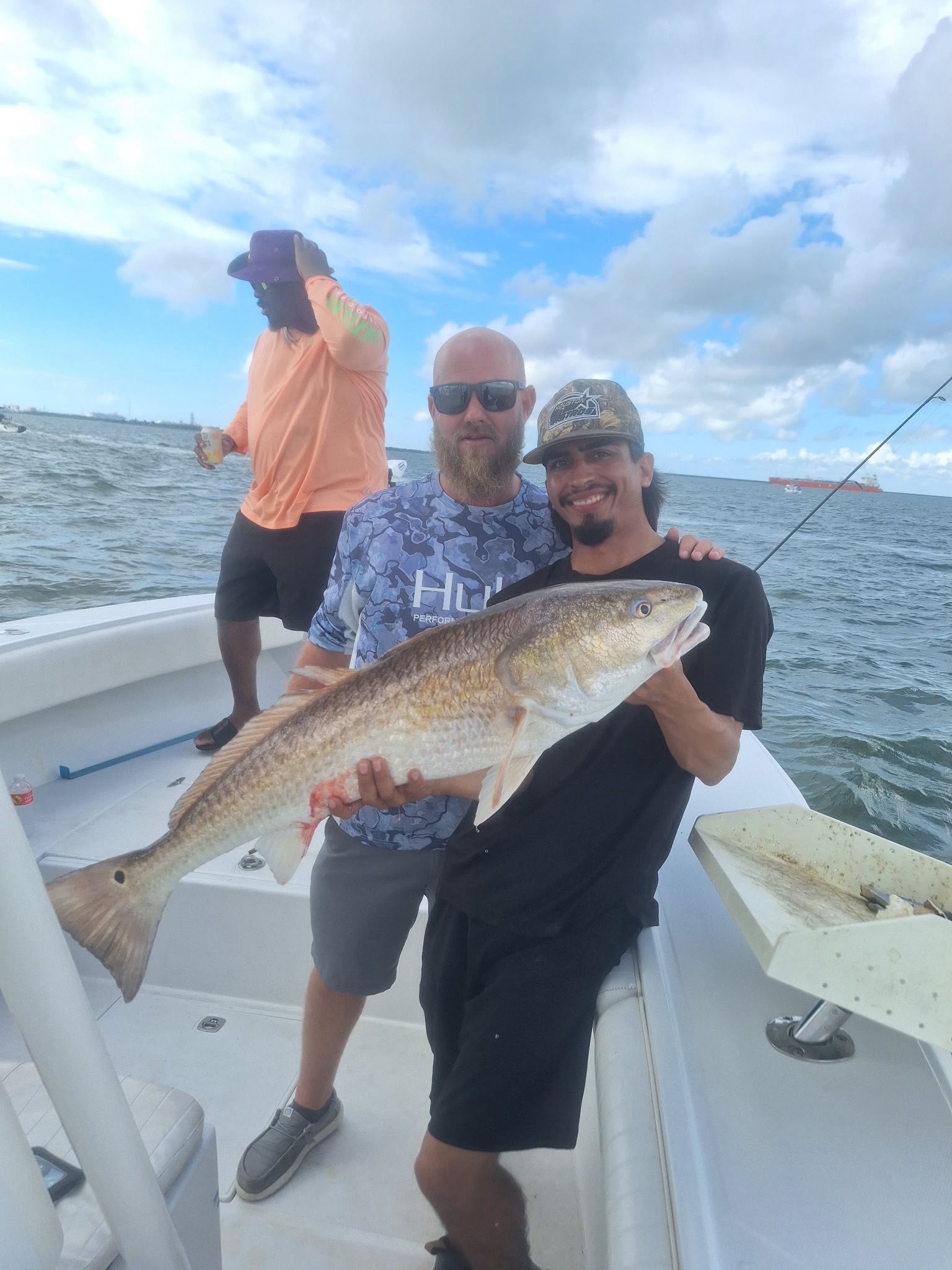 Freshly caught redfish being displayed on fishing boat deck over open water