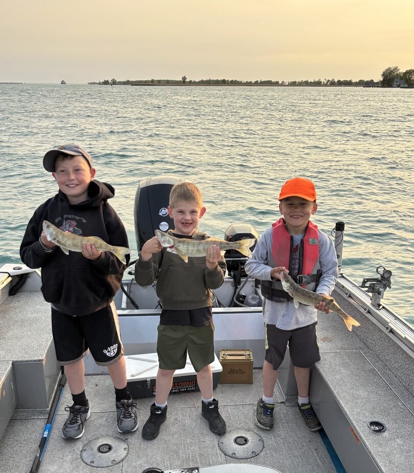 Detroit River walleye fishing charter boat with angler holding fresh caught walleye fish