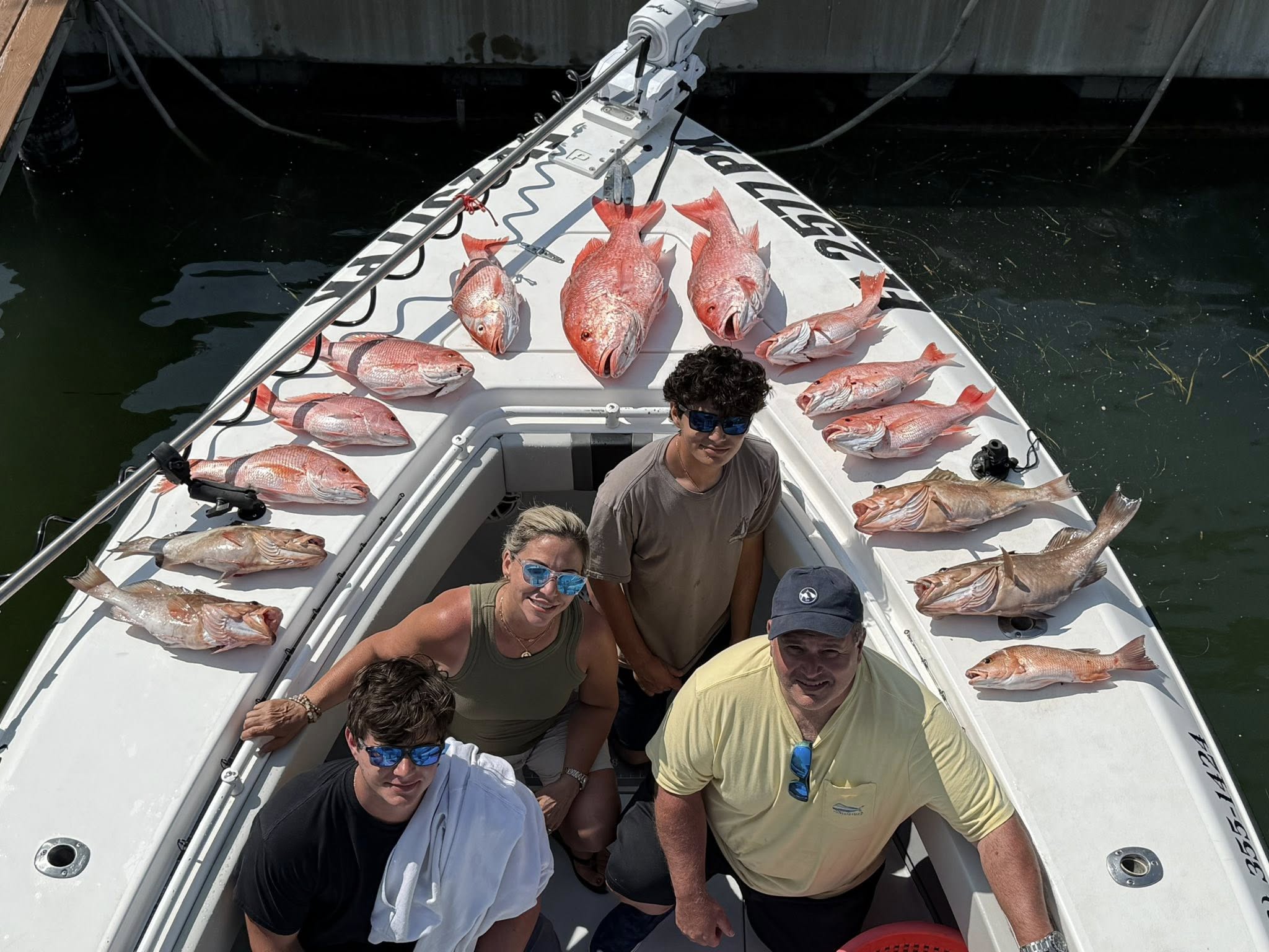 Successful fishing charter in Tierra Verde FL with red grouper and red snapper catch displayed on boat deck