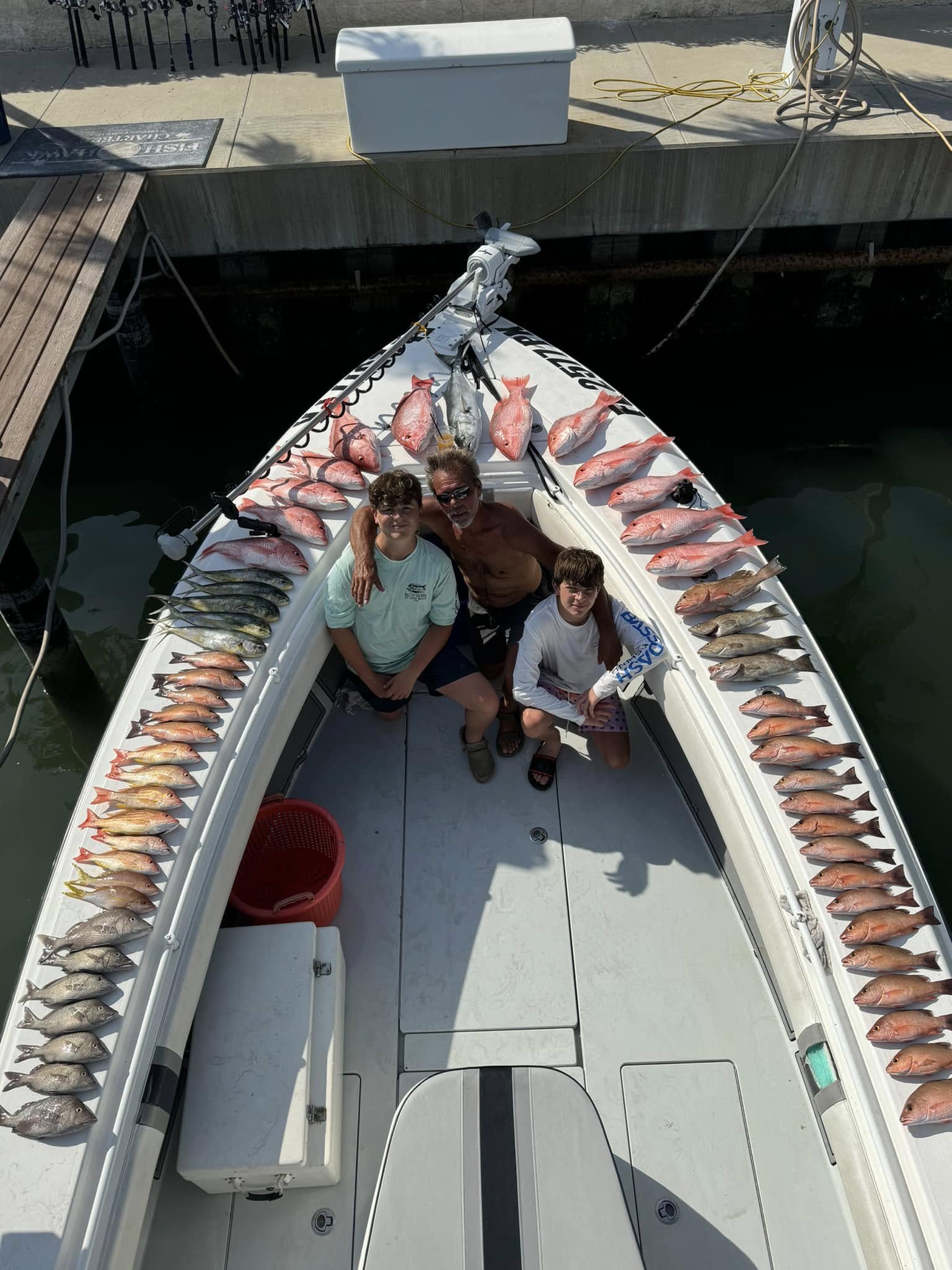 Fishing boat displaying large catch of red snapper and other fish species lined along gunwales at Tierra Verde FL