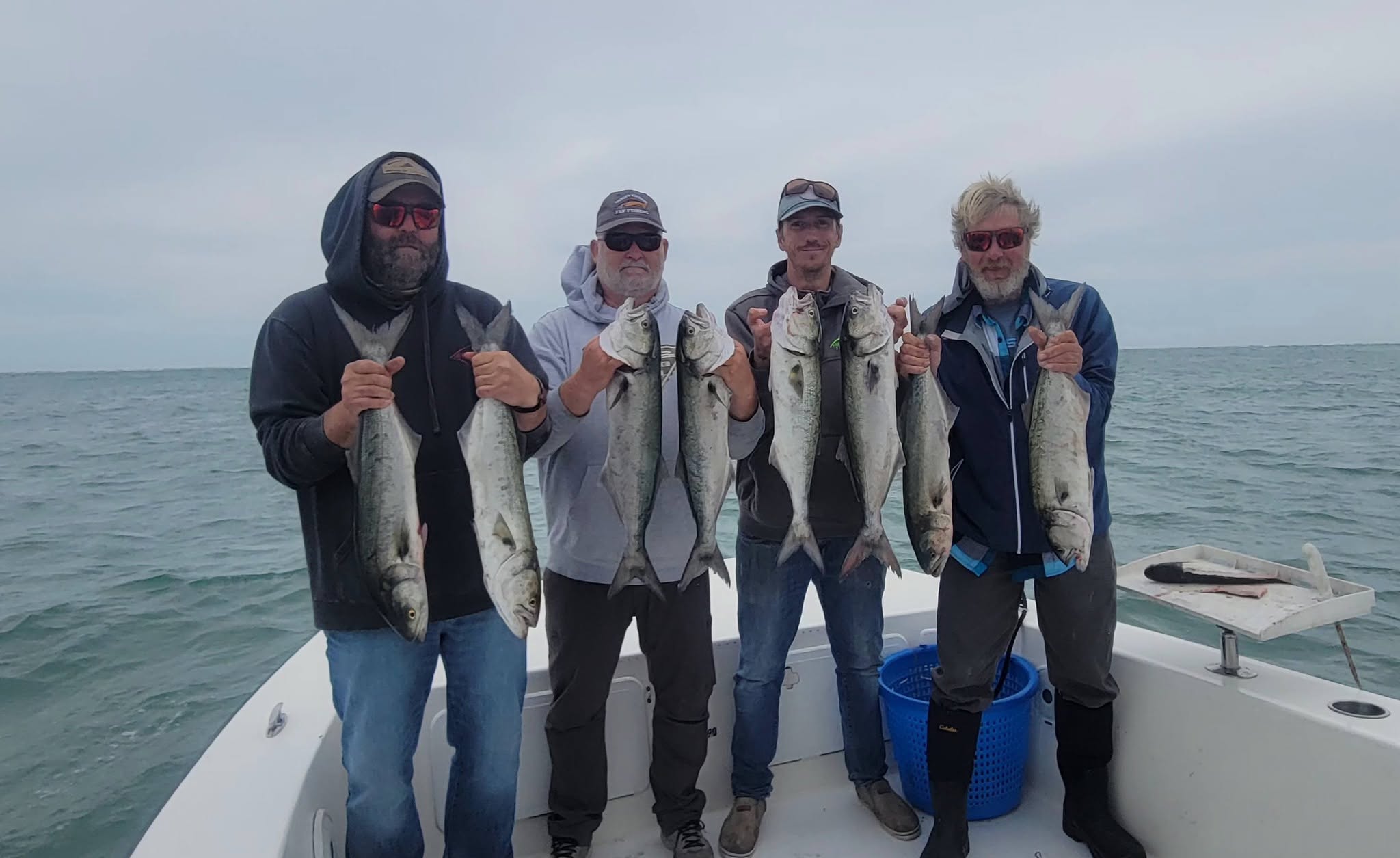 Successful bluefish fishing charter displaying fresh catch on boat deck in Wanchese NC waters