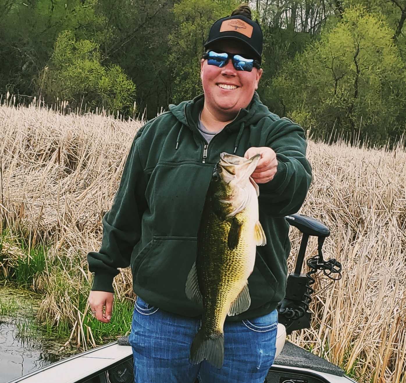 Angler holding large bass catch while fishing in Minneapolis MN