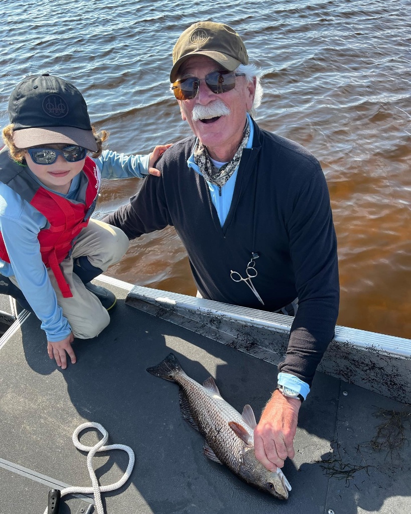 Two anglers pose with a small fish in Wyoming