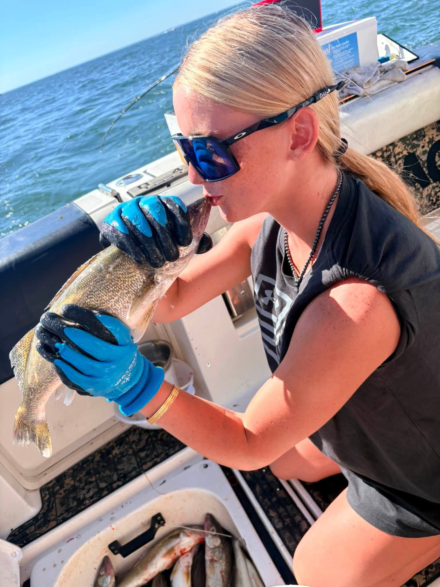 Fish being held on fishing boat deck with ocean in background