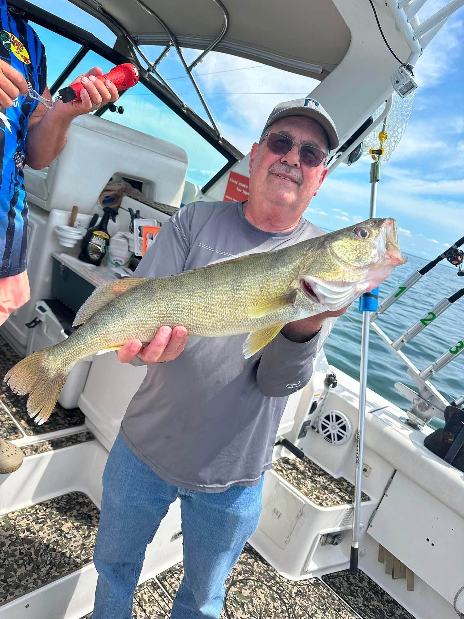 Angler holding freshly caught walleye on fishing boat