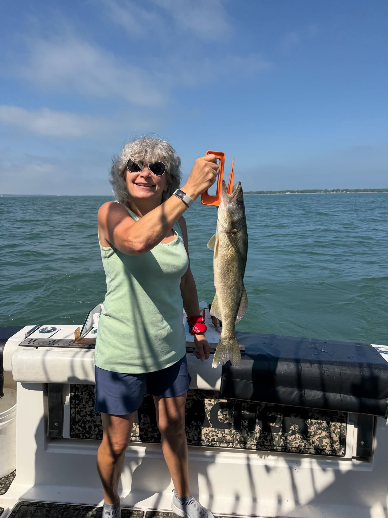 Walleye caught during fishing trip held up for display on boat deck