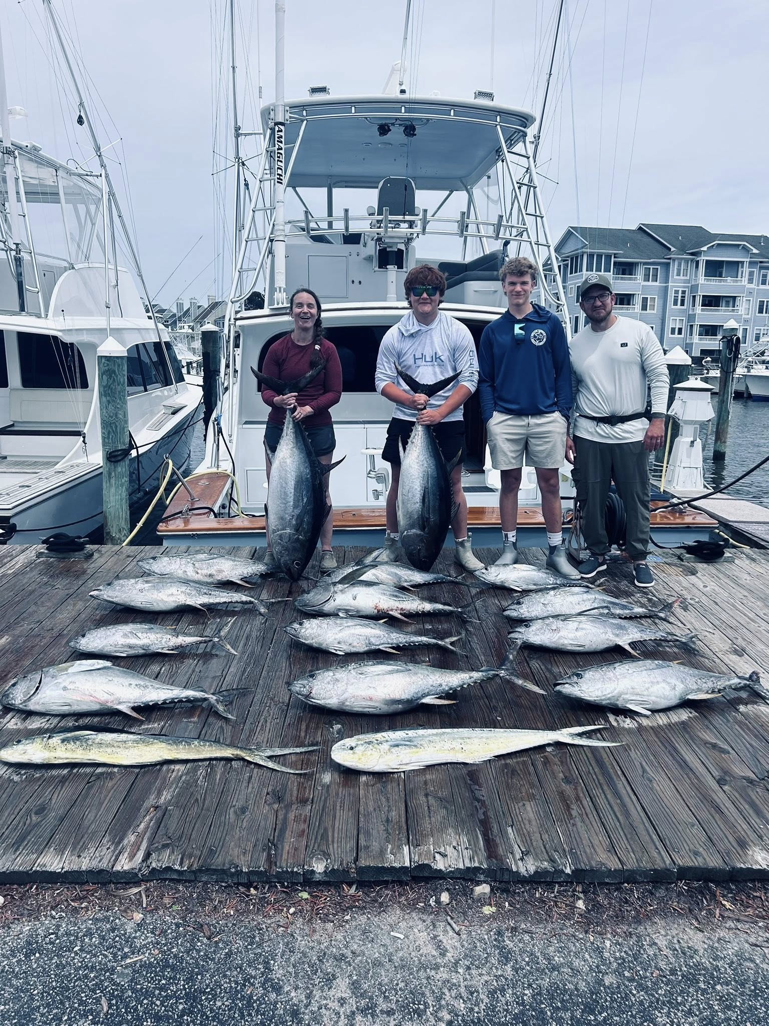 Successful fishing trip in Manteo NC showing multiple species including Mahi Mahi, Yellowfin Tuna, Blackfin Tuna, and Bluefin Tuna laid out on marina dock